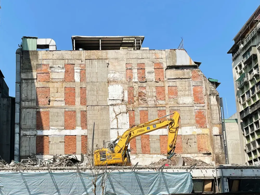A concrete frame with its brick infill panels exposed after the outer facade was removed