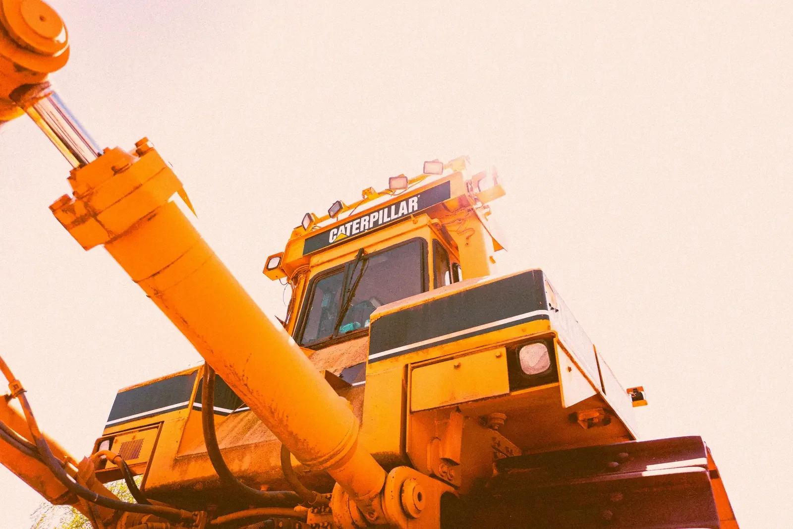 A close view of an excavator cab and boom on a demolition site