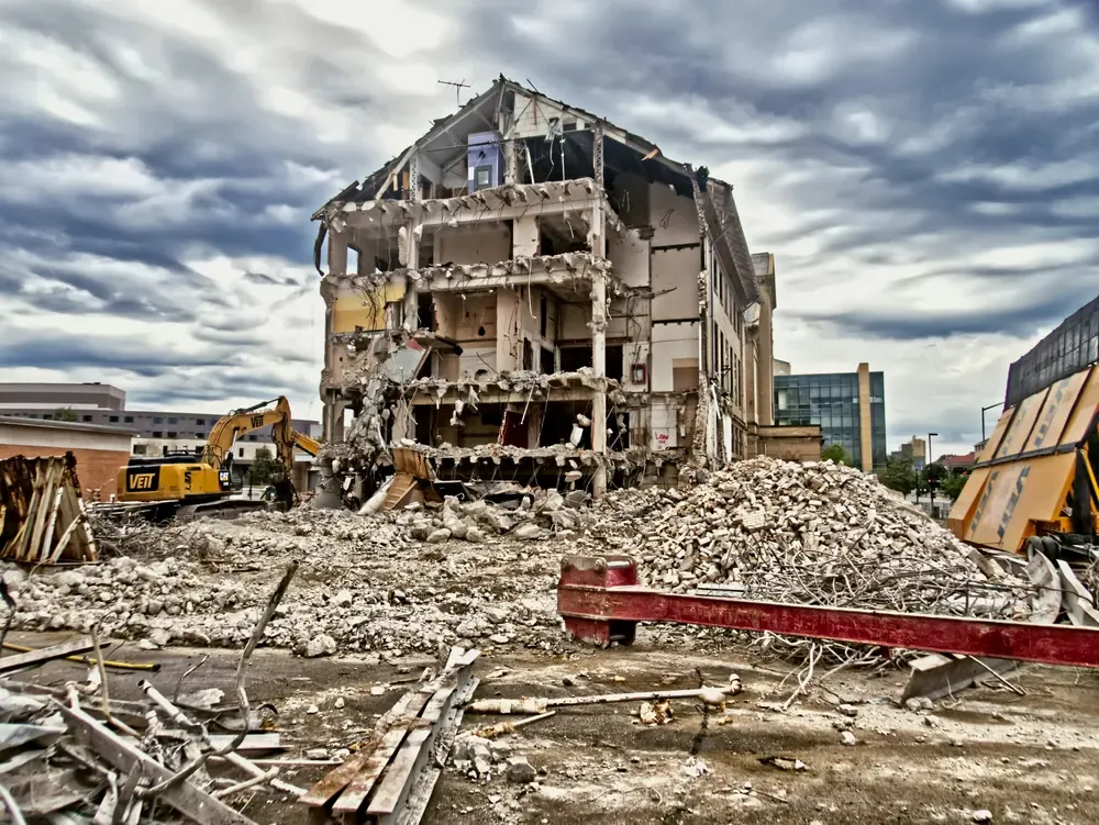A rubble pile in front of a part-demolished multi-storey building in a city street