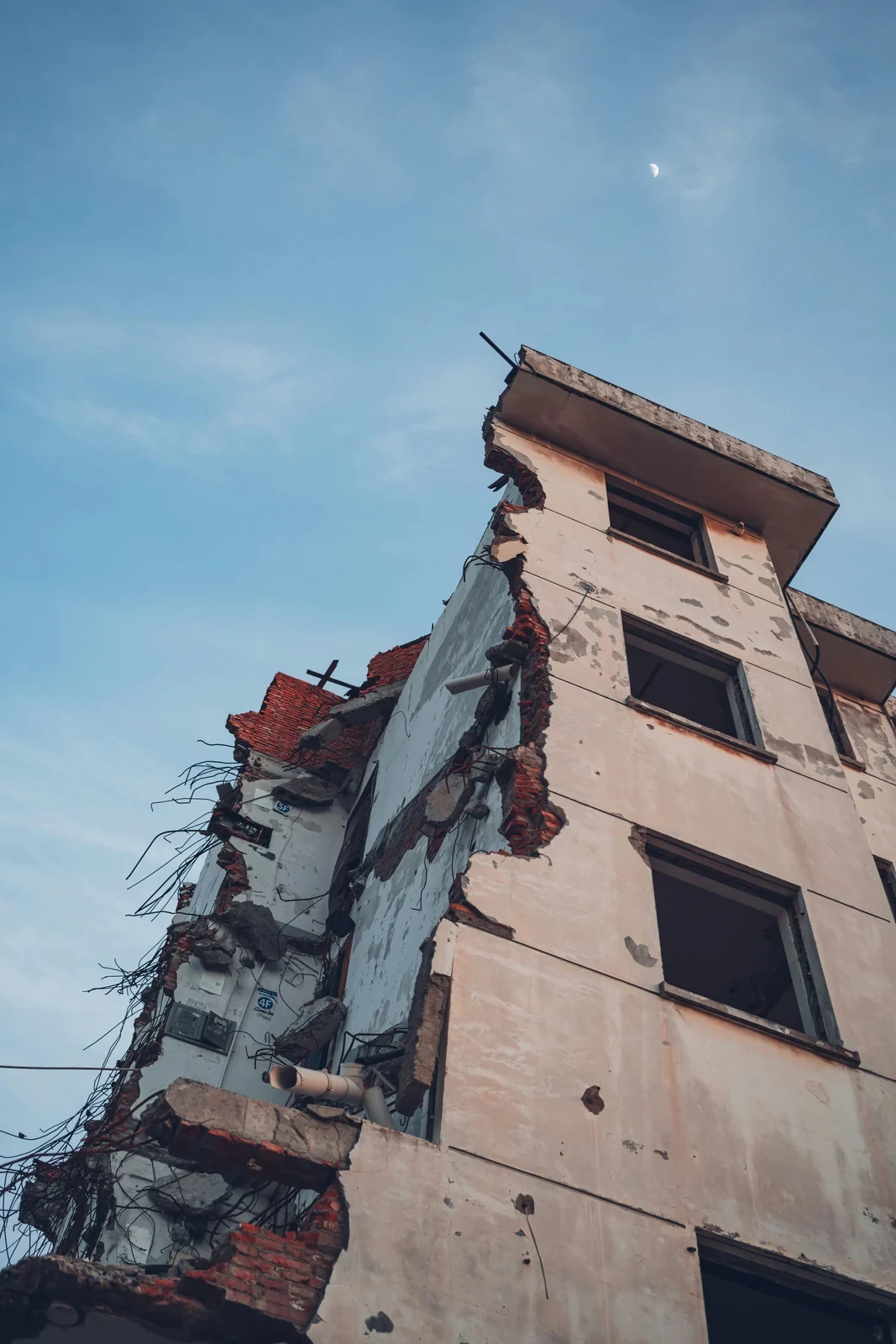 The corner of a building removed, floor slabs and rooms exposed to the outside
